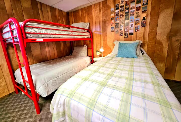 Bunk bed room with red metal bunks and plaid bedding