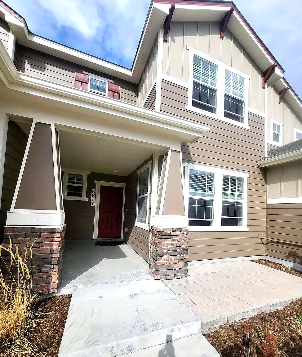 Front entry of 8817 Bella Flora Heights with red door and stone columns