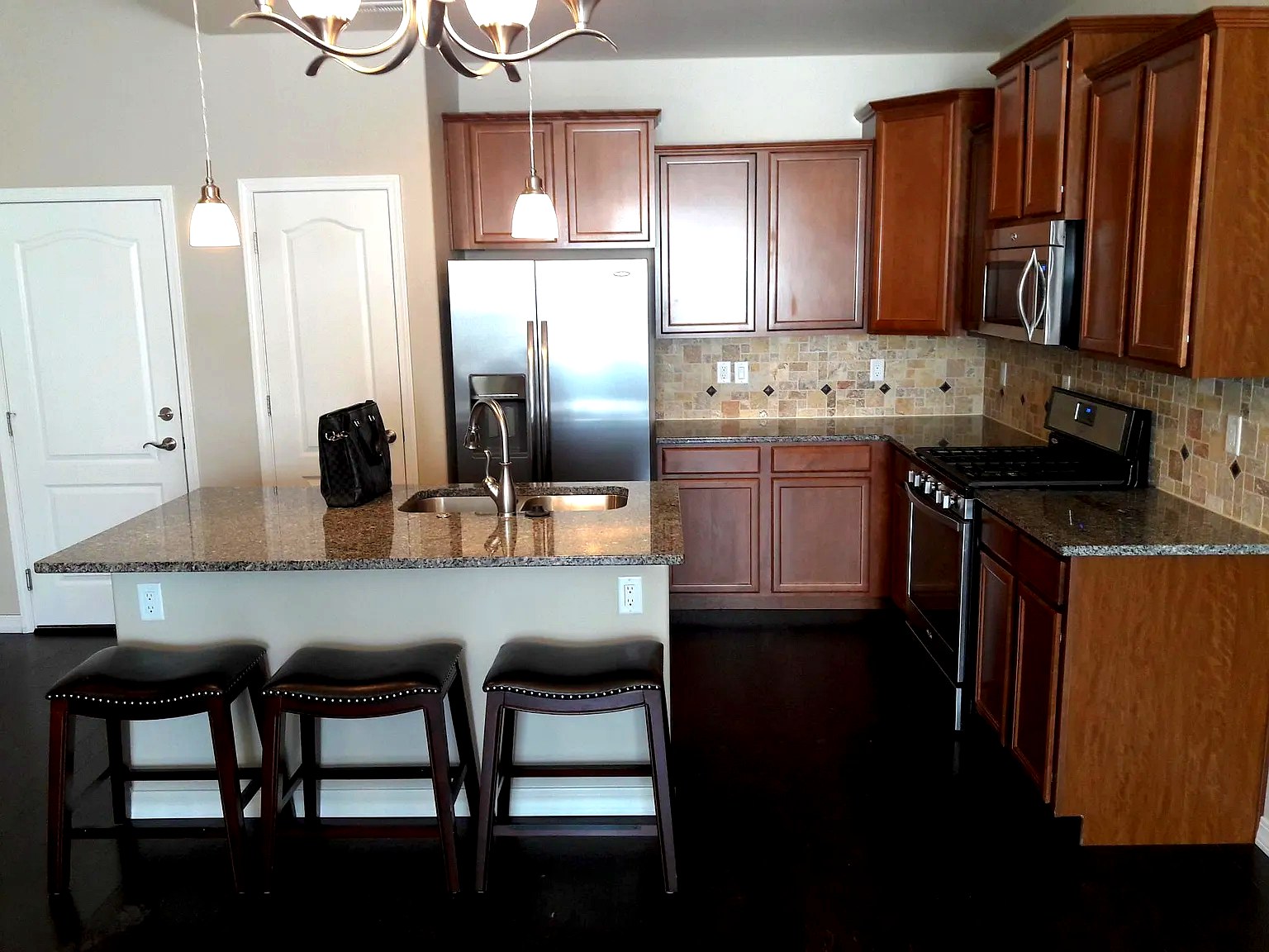 Chef's kitchen with granite island and stainless appliances at Bella Flora, Colorado Springs