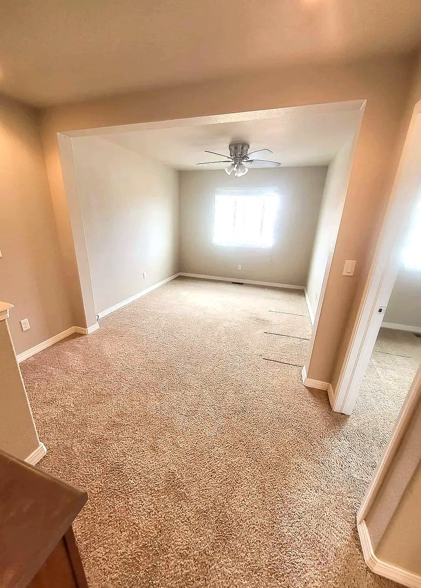 Open living and dining area with plush carpet