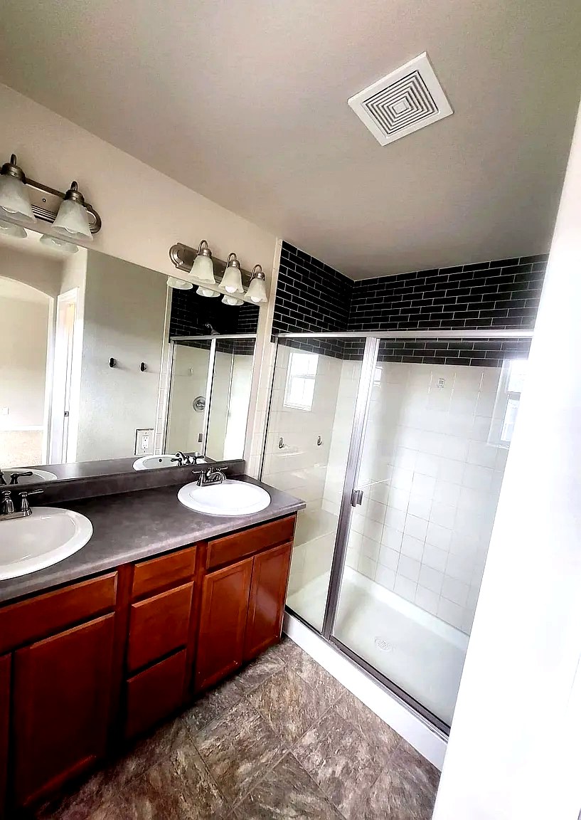 Primary bathroom with double vanity and glass walk-in shower