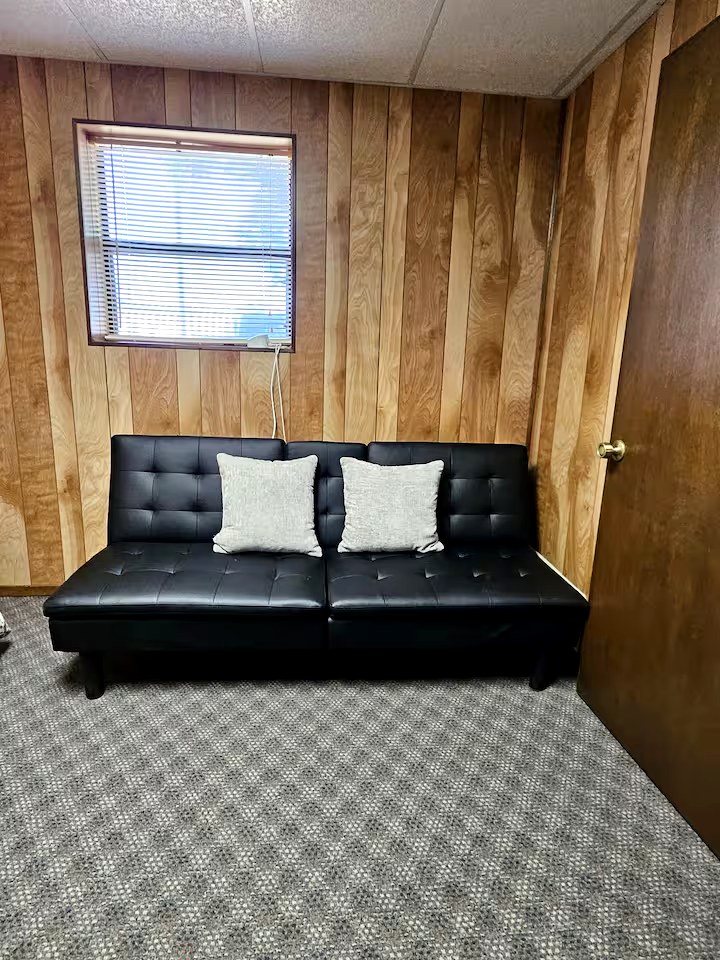 Black futon and additional seating at Papi's Lake House