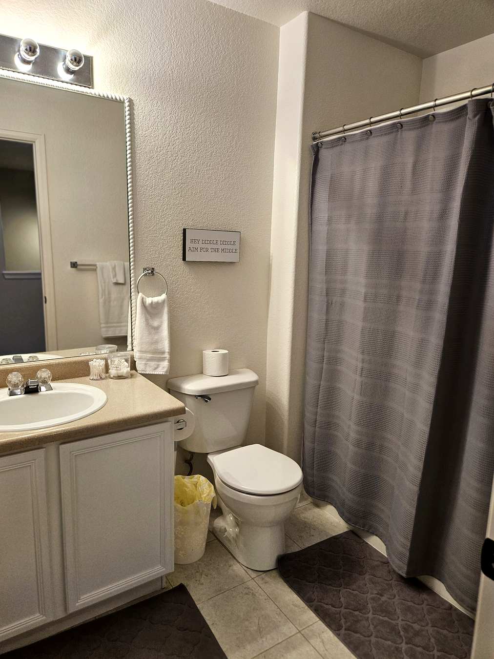 Bathroom with Hollywood vanity mirror lights and white cabinetry