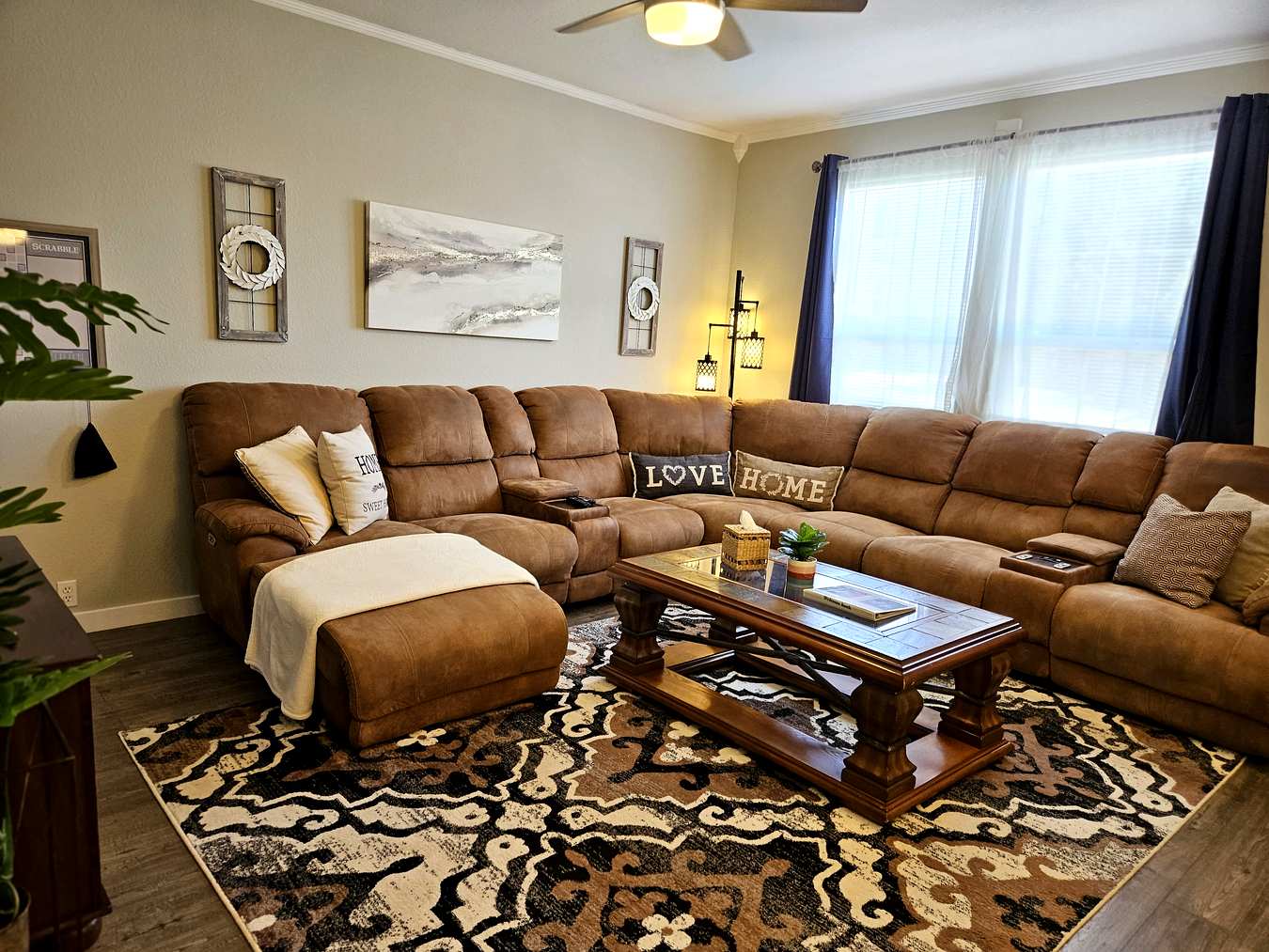 Living room seating area with ceiling fan and natural light