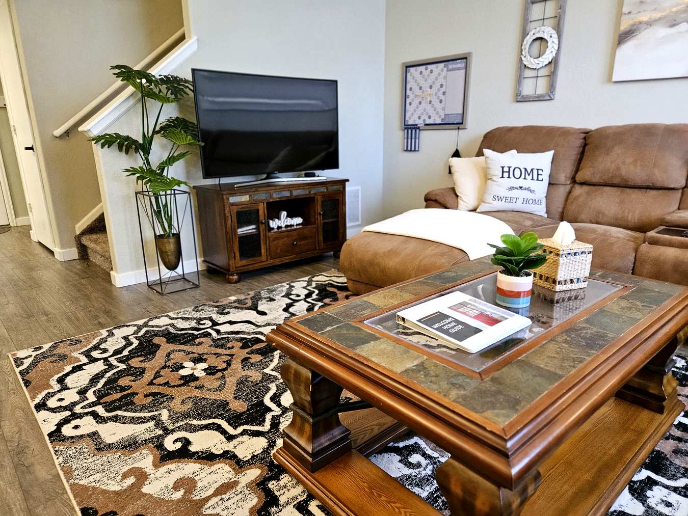 Smart TV entertainment center with staircase and welcome guide