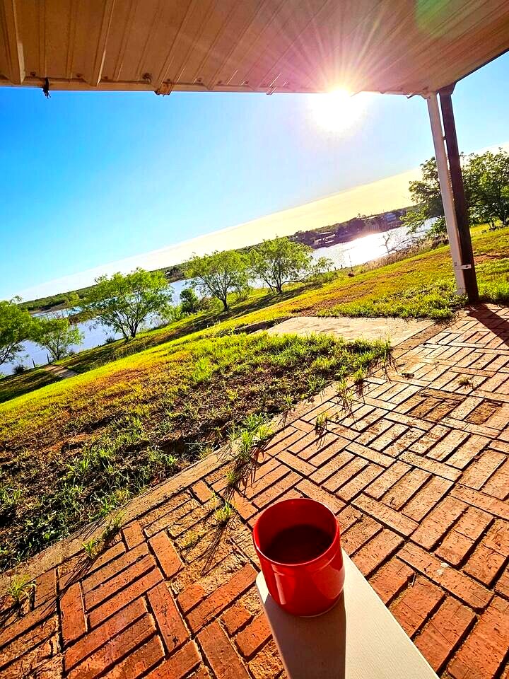 Morning coffee on the covered patio with lake view at Papi's Lake House