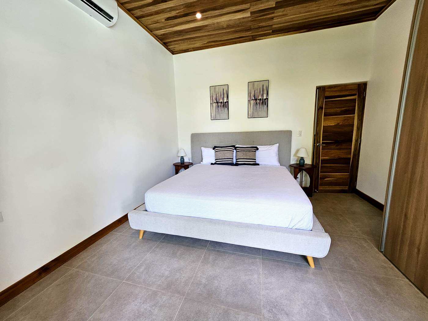 Master bedroom with king bed and wood plank ceiling