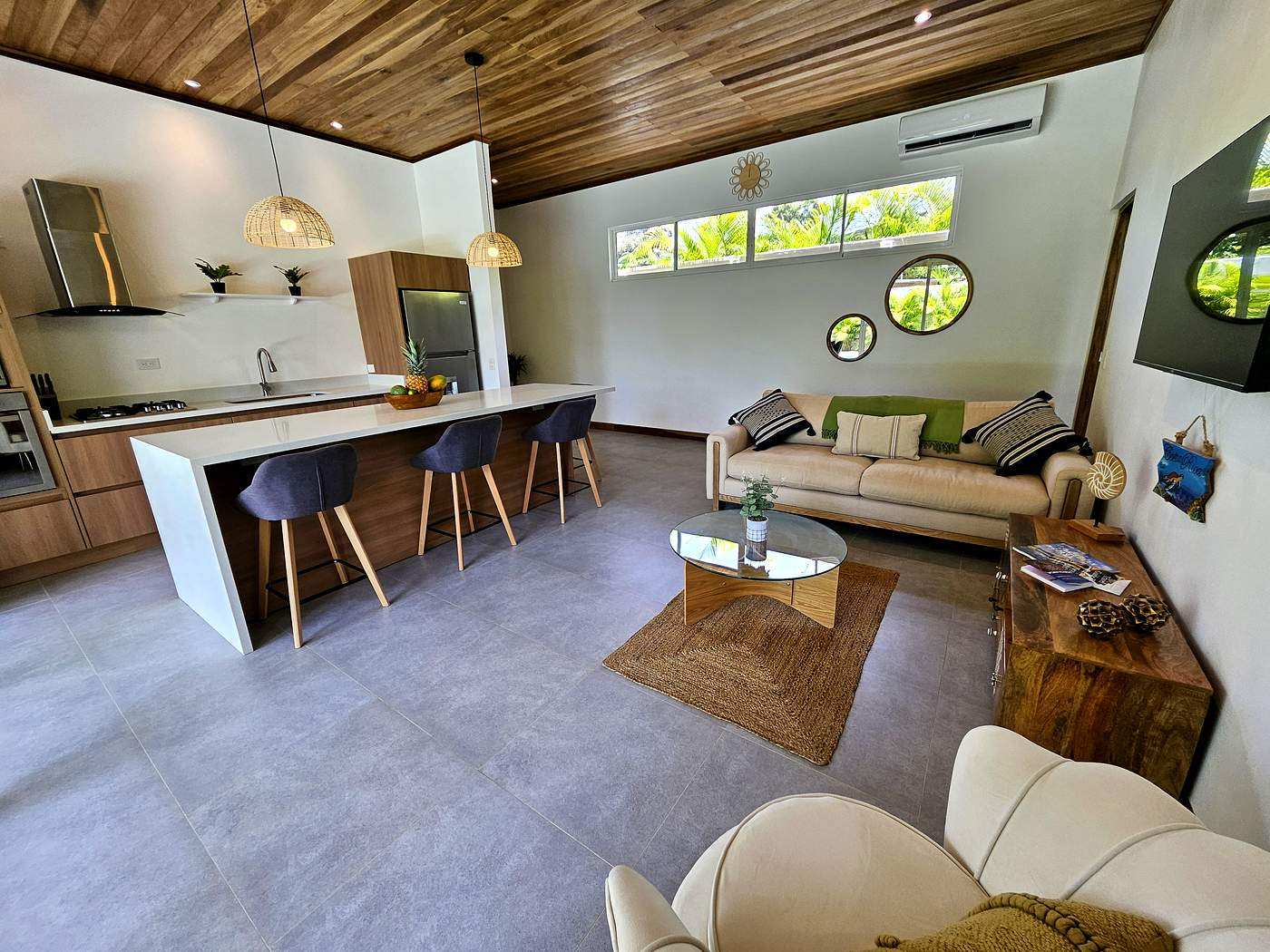 Full open-plan kitchen and living room with tropical garden views