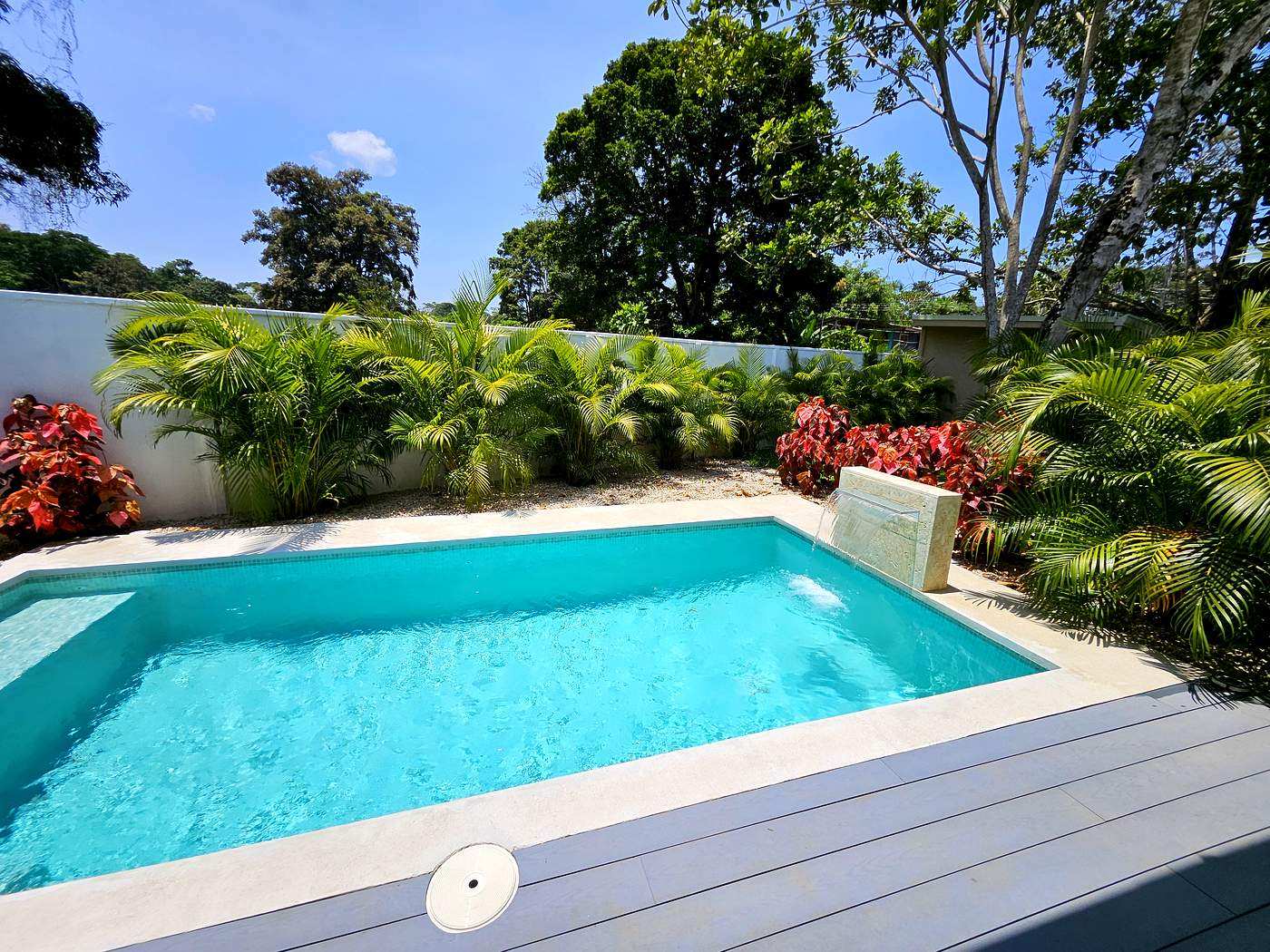 Private pool with stone waterfall feature and lush tropical planting