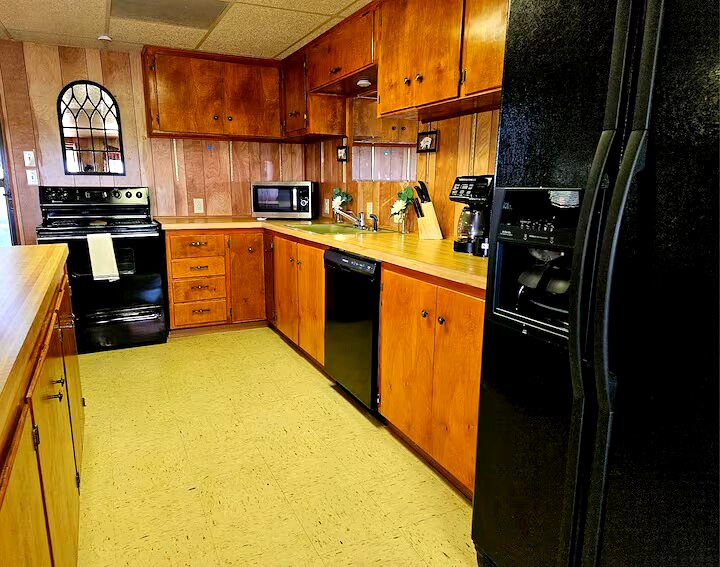 Full kitchen with wooden cabinets, stove and refrigerator