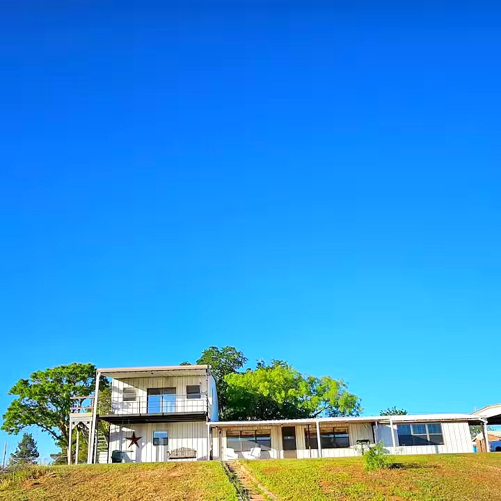Papi's Lake House exterior with green lawn and blue sky
